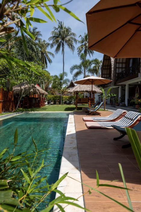 Tropical resort pool with palm trees and private villas in Sri Lanka
